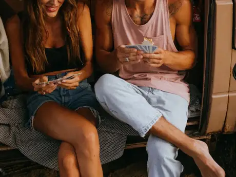 Deux amis assis à l'arrière d'un van, en fin de voyage.