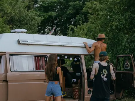 Un van et trois amis qui chargent leurs affaires.